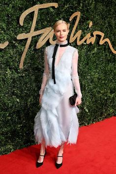 the british fashion awards red carpet is dressed in white and black, with feathers on it