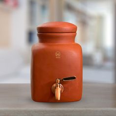 an orange vase sitting on top of a table