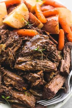 a white plate topped with roast, carrots and potatoes next to a red frame