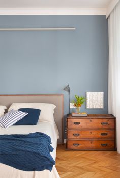 a bedroom with blue walls and wooden floors