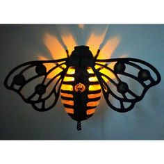 a light that is on the side of a wall with a bee shaped lamp in front of it