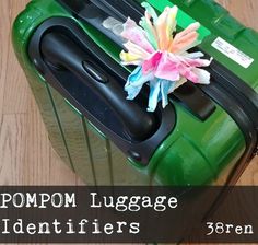 a green piece of luggage sitting on top of a wooden floor next to a pink flower