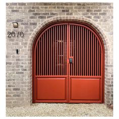 two red doors are open in front of a brick wall