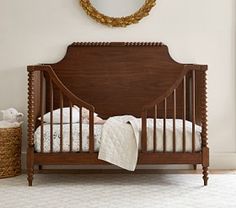 a baby crib in a room with a mirror on the wall