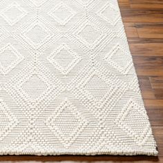 a white rug on top of a wooden floor next to a hard wood flooring