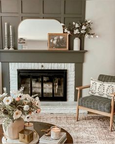 a living room filled with furniture and a fire place in front of a mirror on the wall