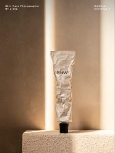 a white tube sitting on top of a counter next to a wall with light coming through it