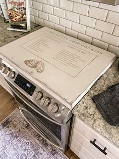 a stove top oven sitting inside of a kitchen next to a counter with an advertisement on it