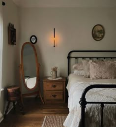 a bed room with a neatly made bed and a mirror