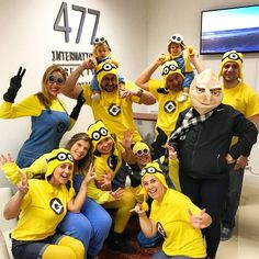 a group of people dressed in yellow and blue posing for the camera with their thumbs up