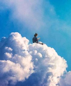 a man sitting on top of a cloud reading a book