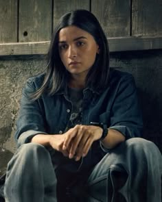 a woman sitting on the ground with her hands folded