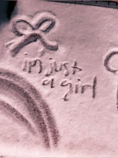 a towel with the words just girls written on it and a cross drawn in sand