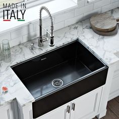 a black sink sitting on top of a white counter next to a faucet