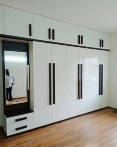 an empty room with white cabinets and black handles on the doors is seen in this image