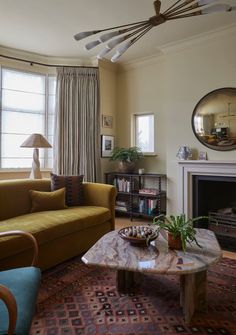 a living room filled with furniture and a fire place in front of a large window