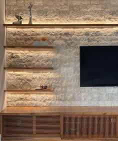 an entertainment center with built in shelves and a flat screen tv mounted on the wall