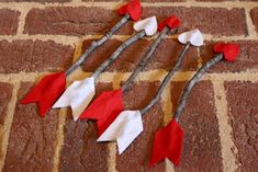 three red and white felt arrows on a brick floor