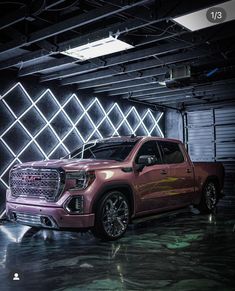 a pink truck parked in a garage next to a wall with geometric designs on it