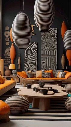 a living room filled with lots of orange and black furniture in front of large round lamps