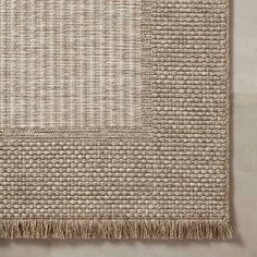 a woven rug with fringes on the bottom and one piece of fabric in the middle