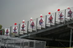 several red and white balloons are attached to the metal railings on this bridge overpass