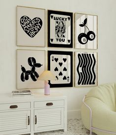 a room with four framed pictures on the wall and a chair in front of it