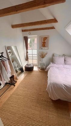 a bed room with a neatly made bed and a mirror