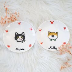 two plates with cats on them sitting on a fur surface