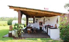 a small outdoor kitchen with an oven on the back wall and table in the middle