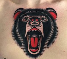 a man with a bear tattoo on his chest showing it's teeth and tongue