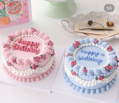 two decorated birthday cakes sitting next to each other on a white counter top, one with the word happy birthday written in frosting