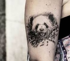 a black and white photo of a panda bear on someone's arm with his head in the background