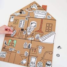 someone is making a house out of cardboard with stickers on the top and bottom