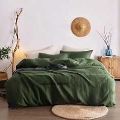 a bed with green linens and pillows in a room next to a wall mounted wicker basket