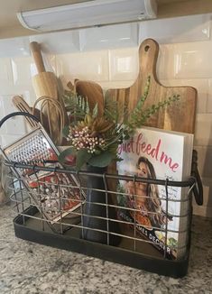 a metal basket filled with cooking utensils and cookbooks on top of a kitchen counter