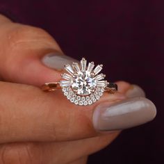 a woman's hand holding an engagement ring with diamonds on the top and bottom