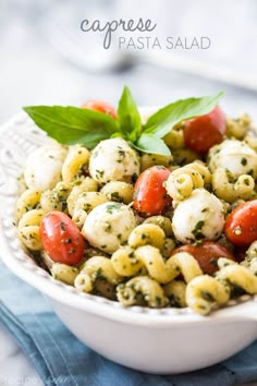 a white bowl filled with pasta salad on top of a blue napkin