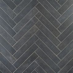 a black and white herringbone tile floor with grey grouting in the middle