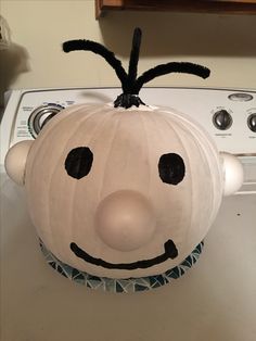 a pumpkin shaped like a face sitting on top of a dryer