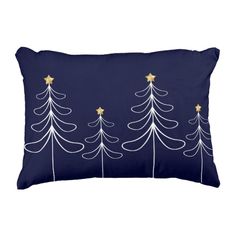 a blue pillow with white christmas trees on the front and gold stars on the back