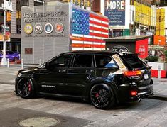 a black suv parked in front of a building with an american flag painted on it