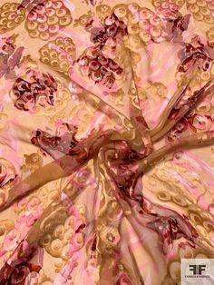 a pink and gold fabric with flowers on it