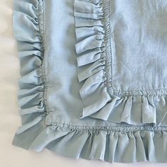 the ruffles on this light blue bed skirt are made from cotton and linen