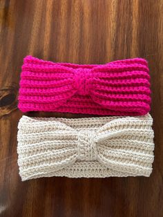 two crocheted headbands sitting on top of a wooden table