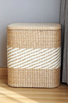 a wicker basket sitting on top of a hard wood floor next to a window