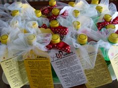 several yellow and white tags with red bows on them are attached to some wine bottles