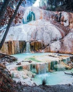 the water is blue and green as it sits in front of an ice covered mountain