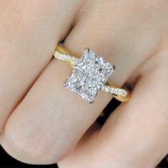 a woman's hand with a yellow and white diamond ring on top of her finger