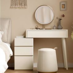 a white vanity table with a mirror and stool next to it in a bedroom setting